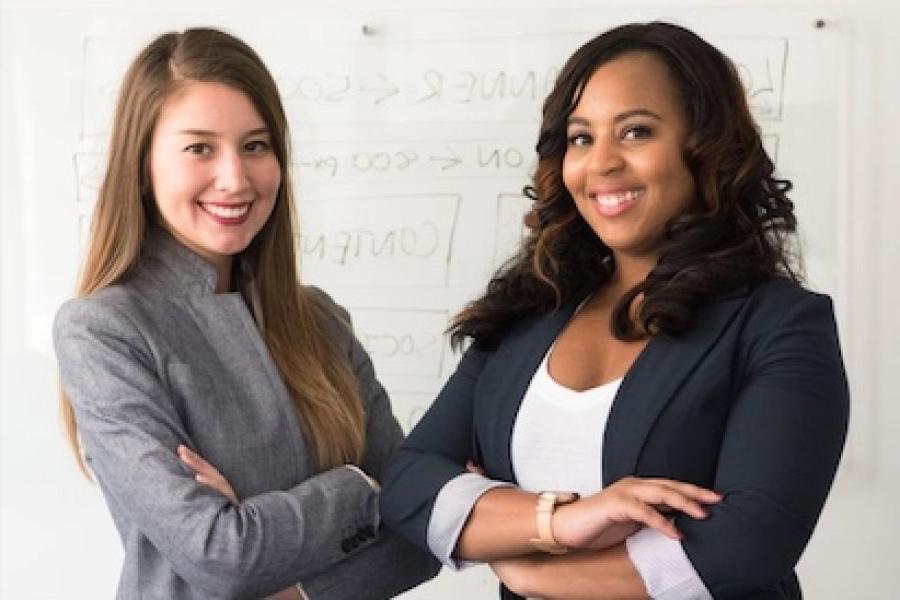 Two students in suits smiling