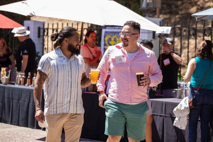 Two young men hold beers