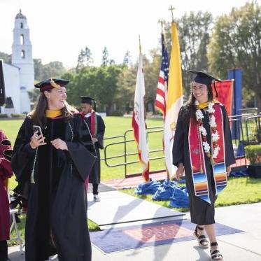 EES Student in graduation garb walking across the stage