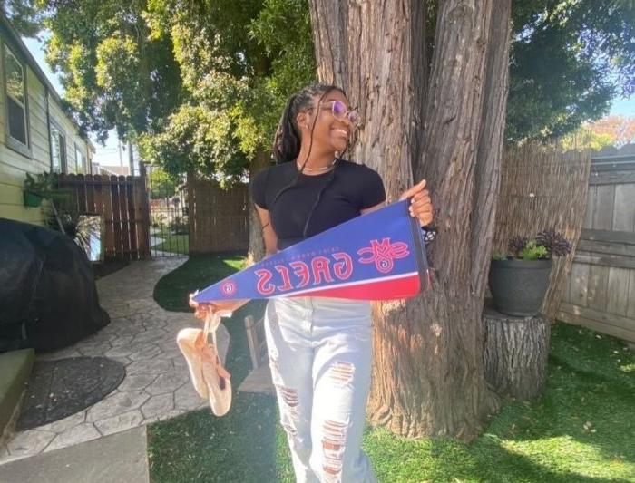 A young woman holds a Saint Mary's pennant