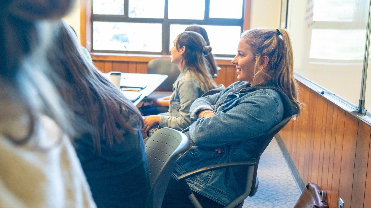 A student sitting in class smiling